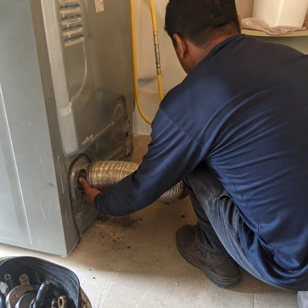 Technician performing professional dryer vent cleaning service